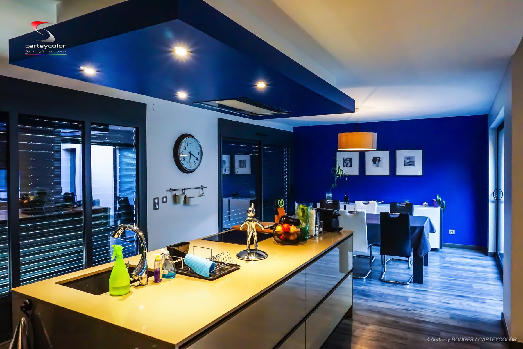 Cuisine ouverte au plafond suspendu bleu et salle à manger au mur bleu profond