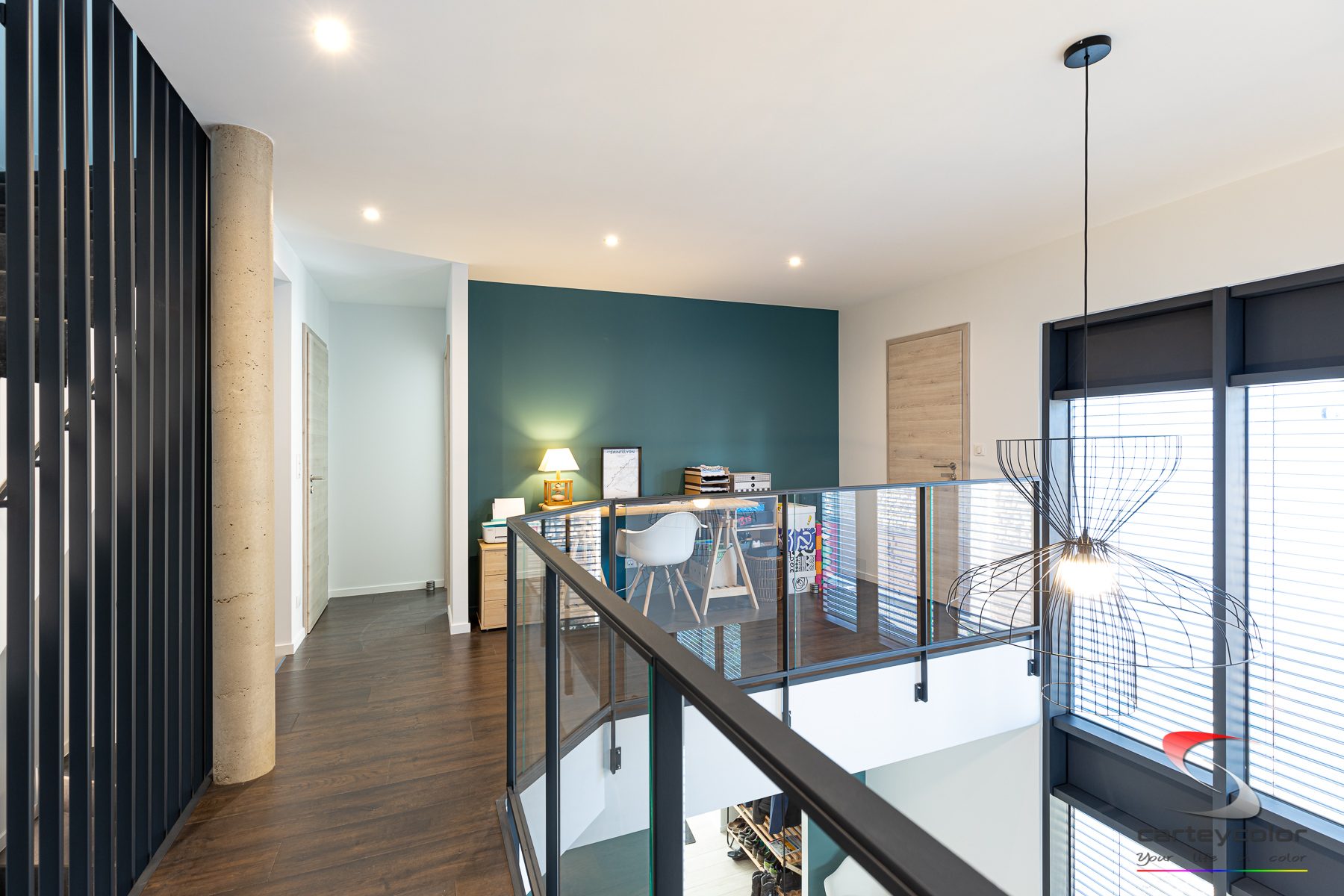 Mezzanine au parquet foncé et mur bleu pétrole